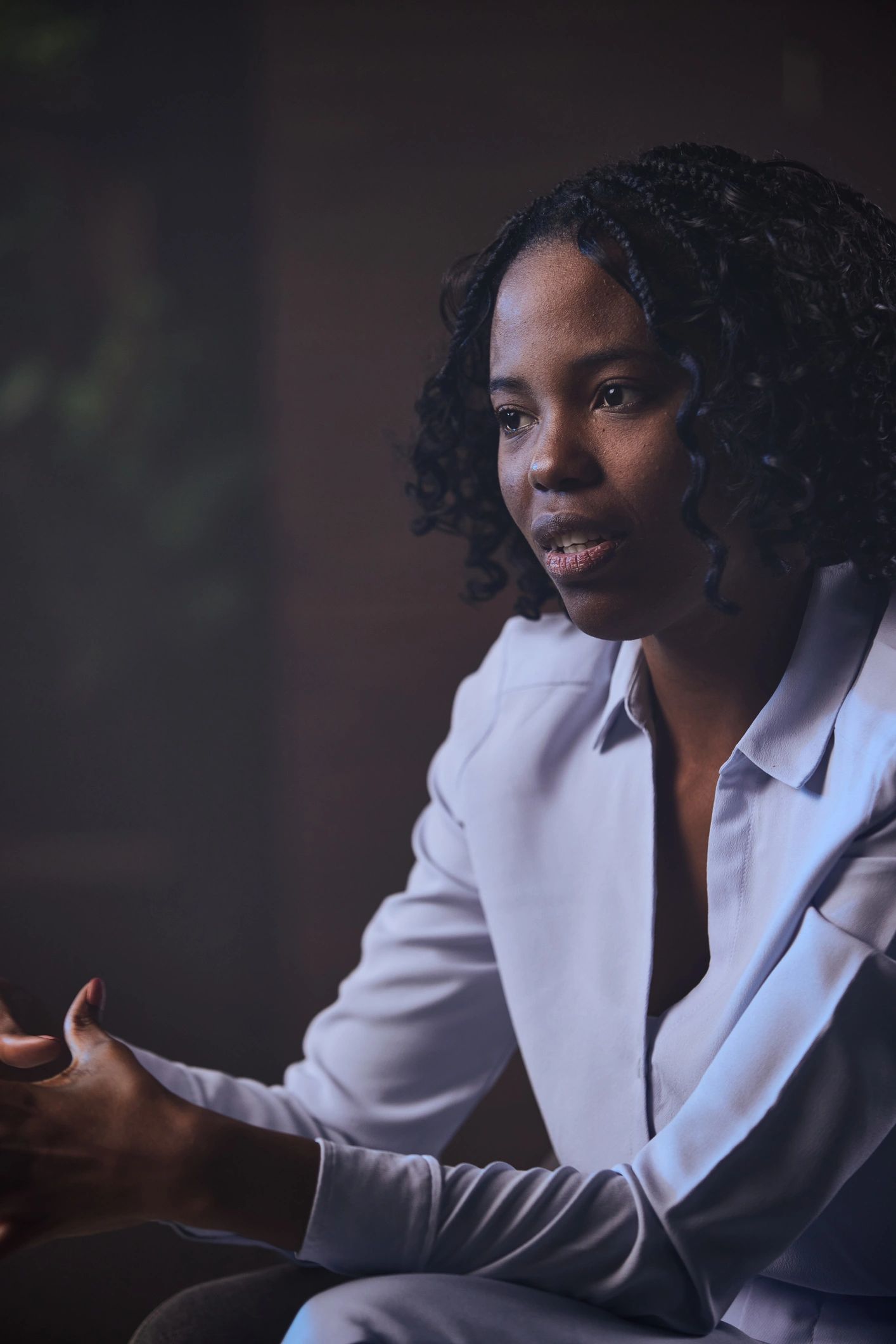 Professional woman speaking thoughtfully in a meeting
